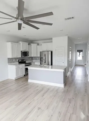 a room with a sink cabinets and wooden floor