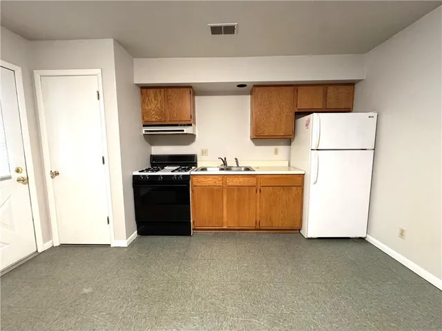 a kitchen with a refrigerator and a stove