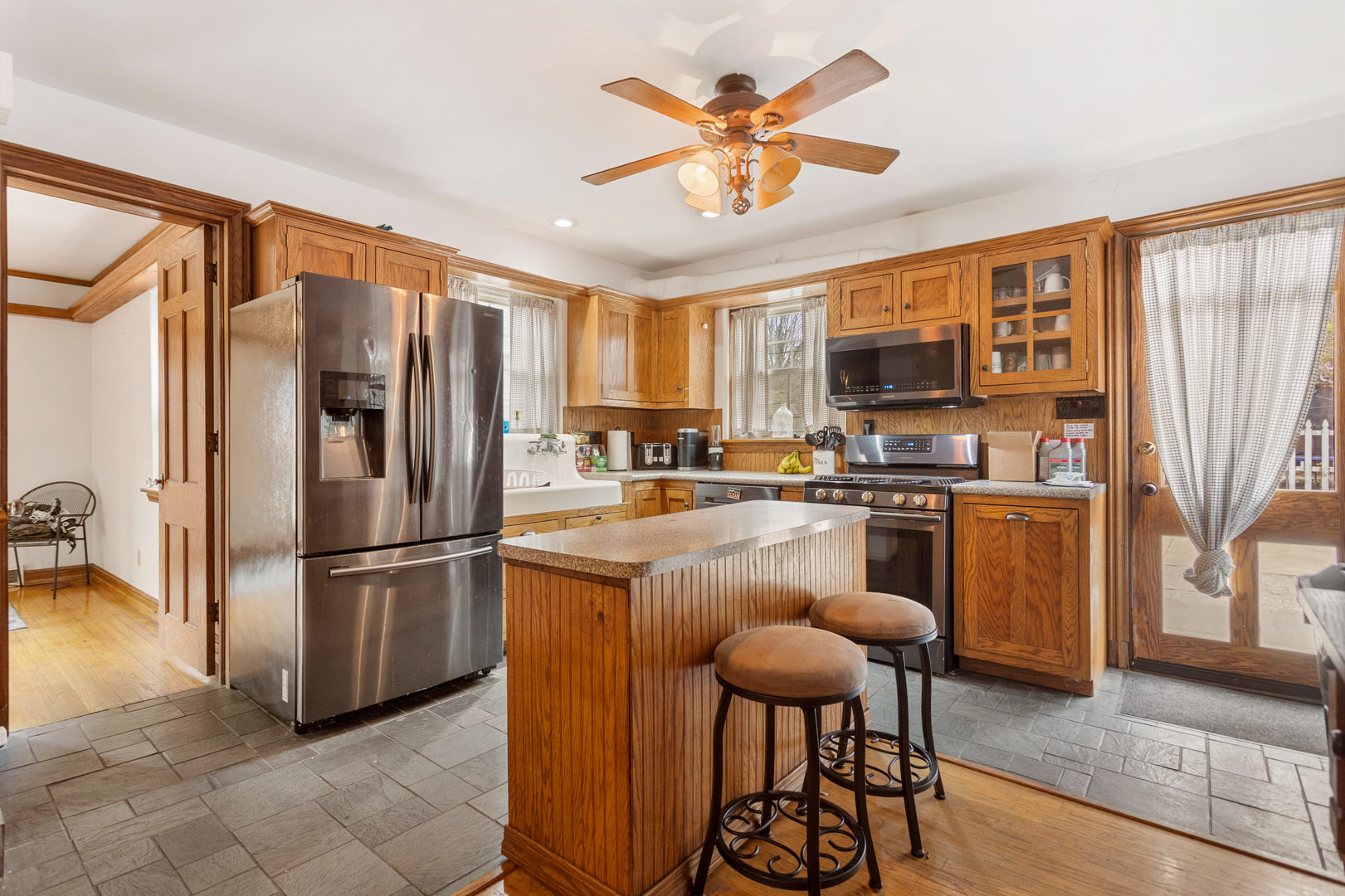 901 West Green Street Champaign, IL 61821 - Photo 15 of 36 a kitchen with stainless steel appliances granite countertop a refrigerator a stove a sink a dining table and chairs with wooden floor