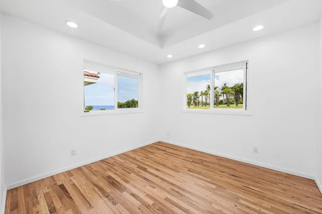 an empty room with wooden floor and window
