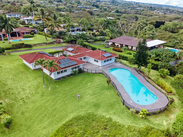 an aerial view of residential houses with outdoor space and swimming pool