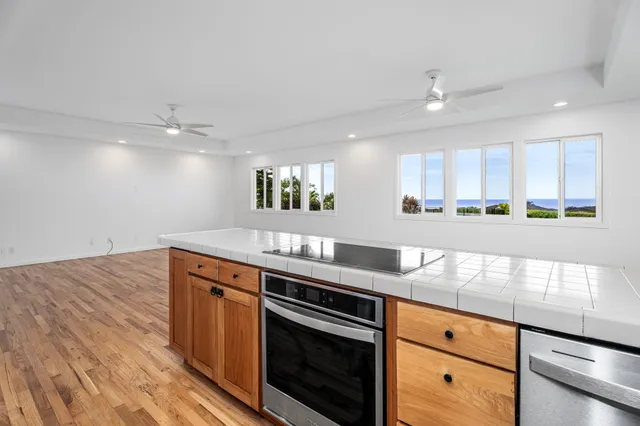 a kitchen with stainless steel appliances granite countertop a sink a stove and a wooden floors