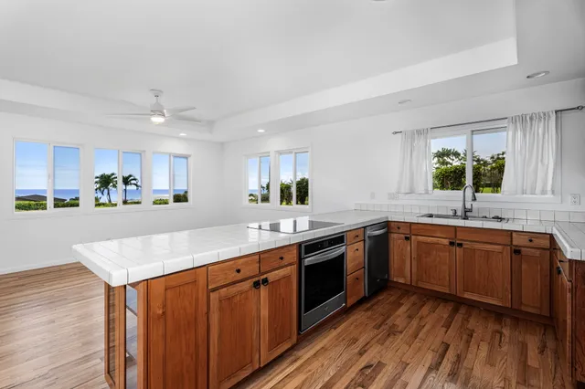 a kitchen with stainless steel appliances granite countertop wooden cabinets and sink