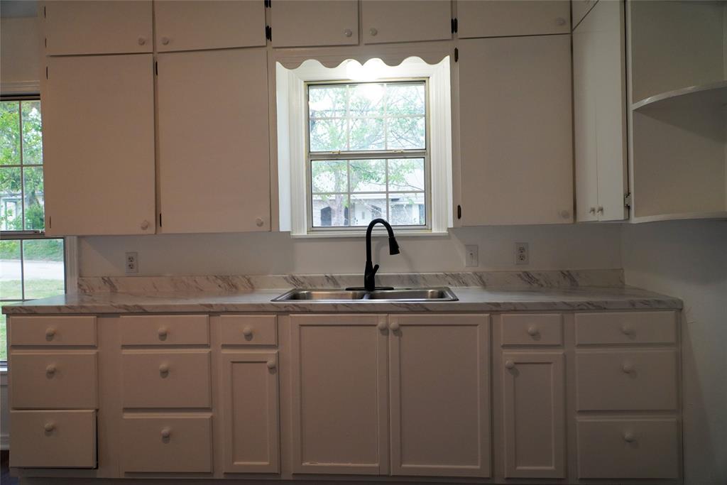 403 North Fairview Street Keene, TX 76059 - Photo 11 of 25 a kitchen with white cabinets window and sink