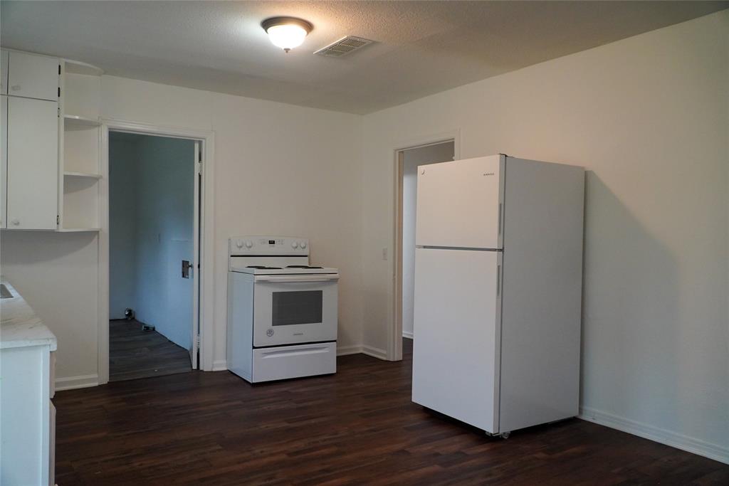 403 North Fairview Street Keene, TX 76059 - Photo 13 of 25 a white refrigerator freezer and a wooden floor