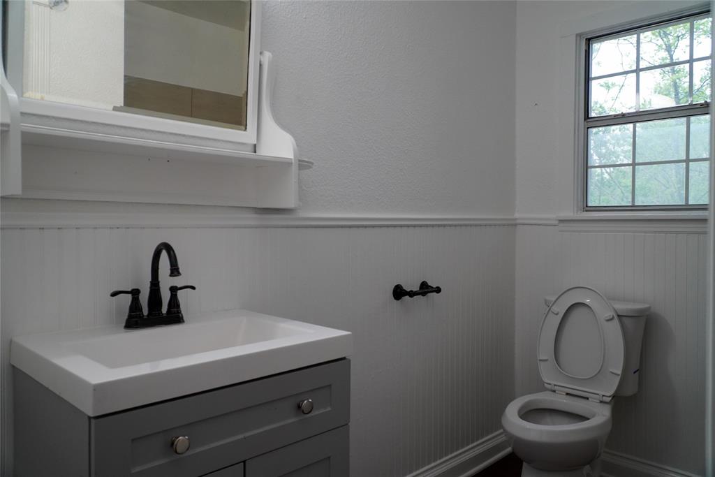 403 North Fairview Street Keene, TX 76059 - Photo 15 of 25 a bathroom with a toilet sink and mirror