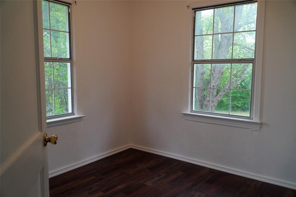 403 North Fairview Street Keene, TX 76059 - Photo 19 of 25 an empty room with wooden floor and windows