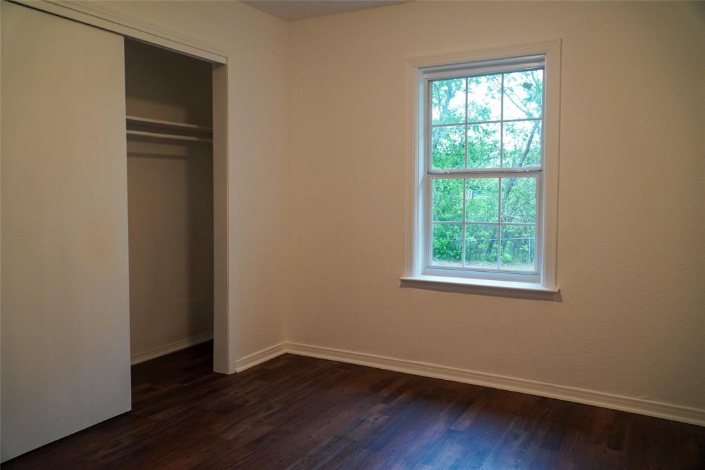403 North Fairview Street Keene, TX 76059 - Photo 20 of 25 a view of an empty room with wooden floor and a window