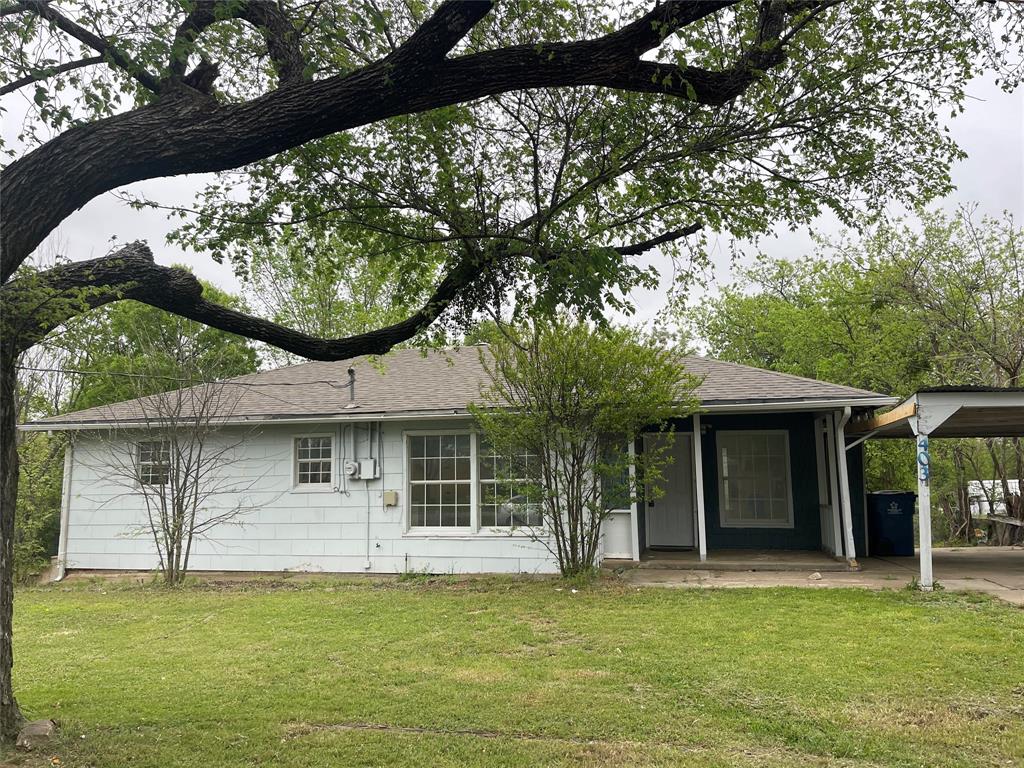 403 North Fairview Street Keene, TX 76059 - Photo 6 of 25 a view of a white house with a large window and a large tree
