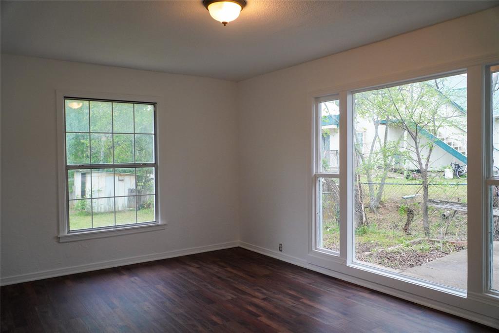 403 North Fairview Street Keene, TX 76059 - Photo 7 of 25 an empty room with wooden floor and windows