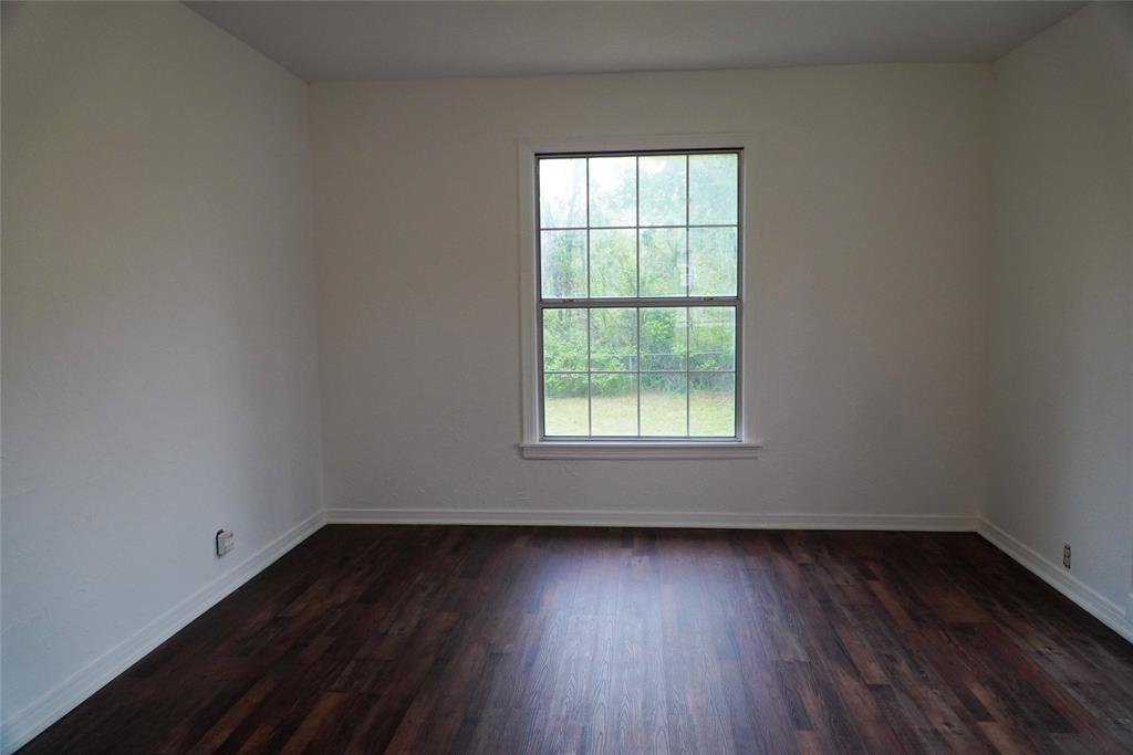 403 North Fairview Street Keene, TX 76059 - Photo 8 of 25 an empty room with wooden floor and windows