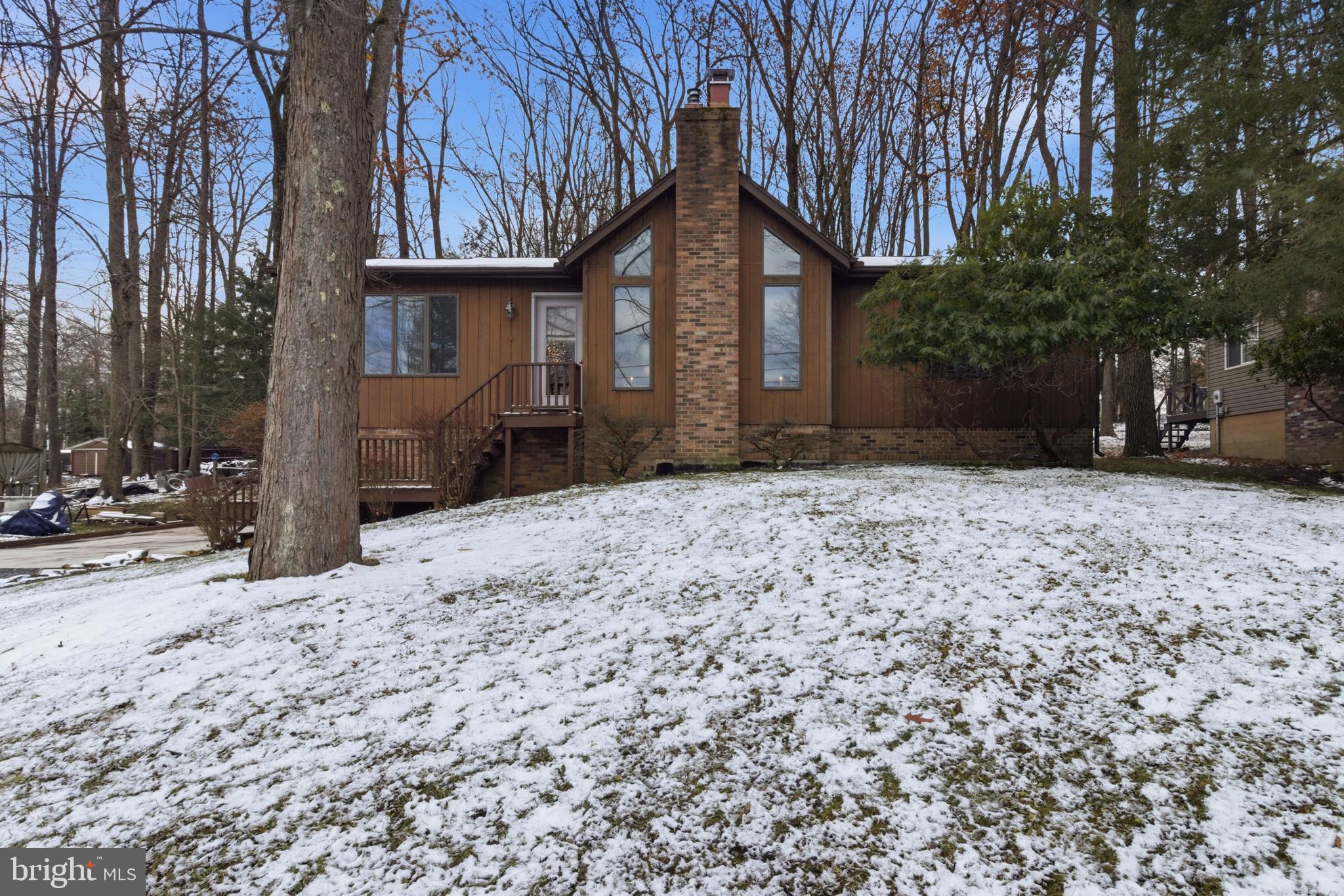 a front view of a house with a yard covered in snow