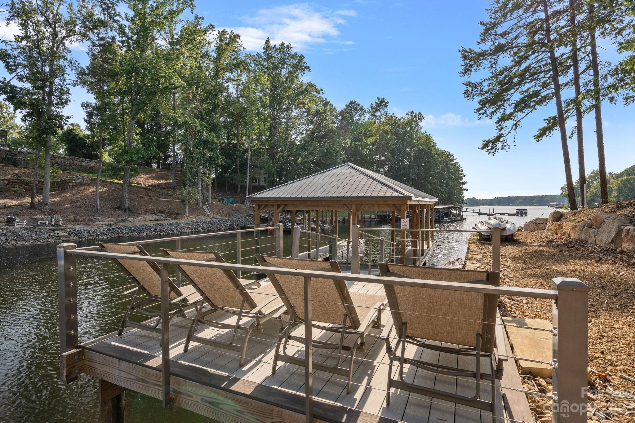 222 Greenbay Road Mooresville, NC 28117 - Photo 38 of 44 a view of a roof deck with table and chairs under an umbrella