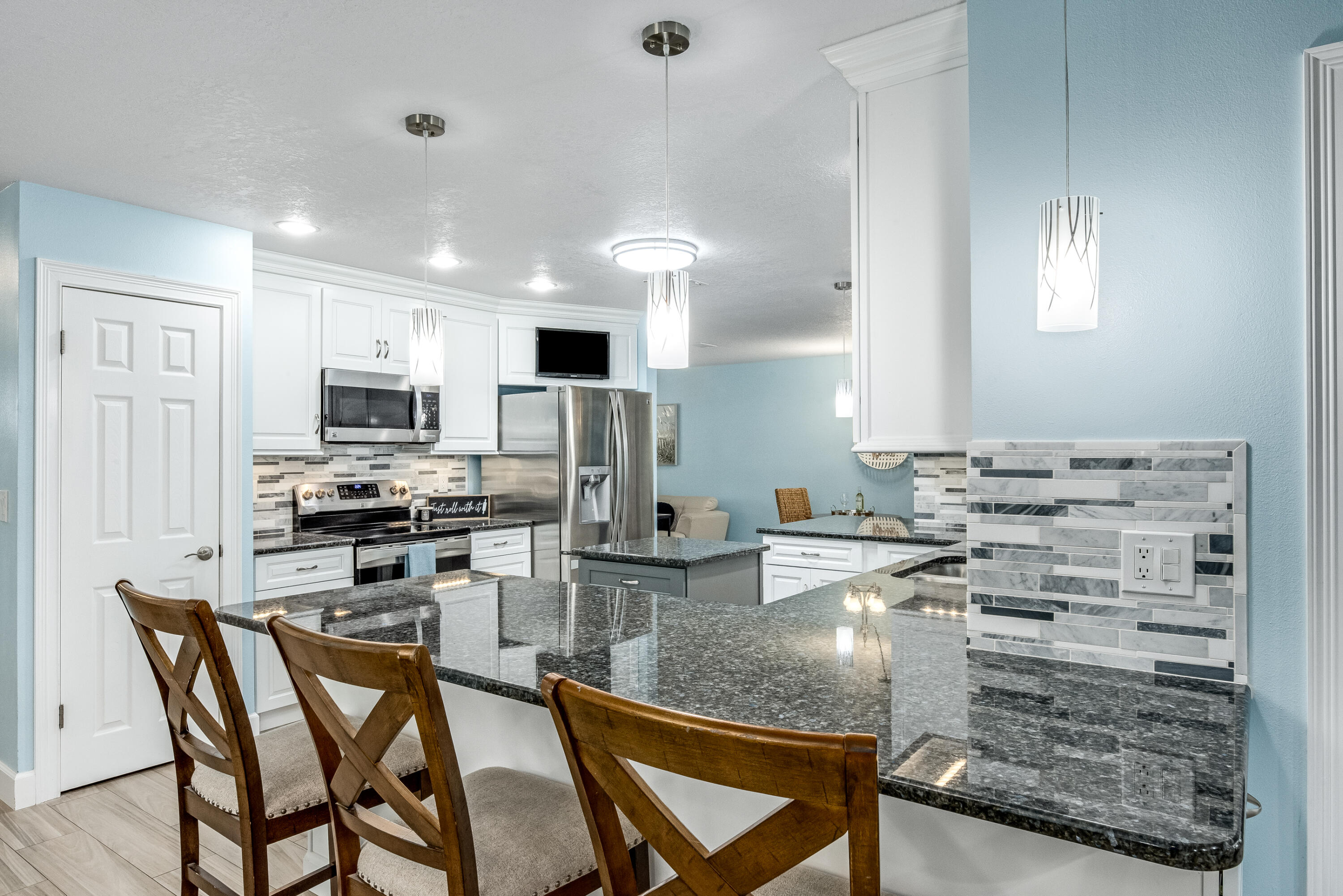 415 Wayne Avenue Indialantic, FL 32903 - Photo 12 of 63 a kitchen with kitchen island granite countertop a stove cabinets and chairs