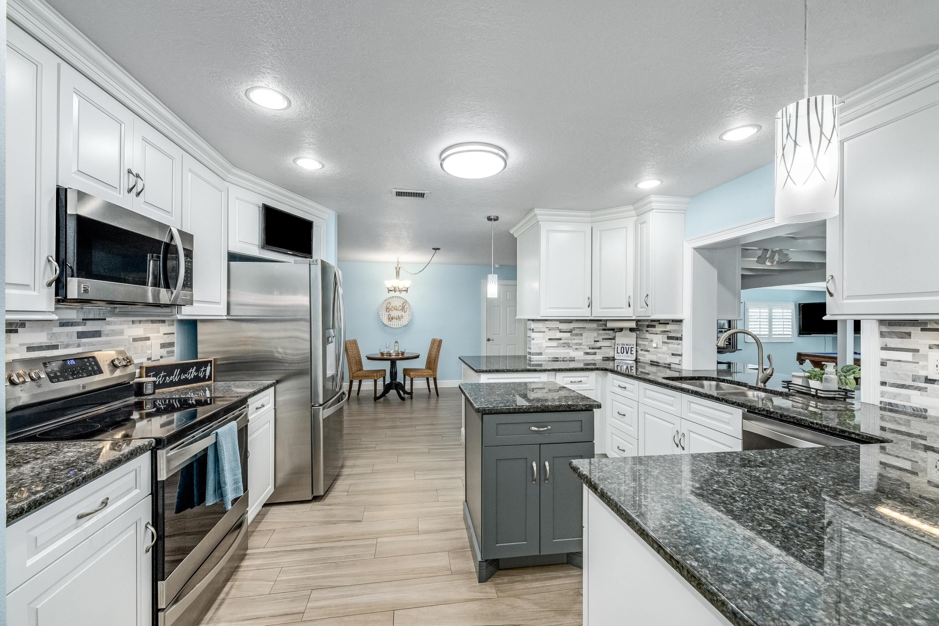 415 Wayne Avenue Indialantic, FL 32903 - Photo 13 of 63 a kitchen with stainless steel appliances granite countertop a stove top oven a sink dishwasher a dining table and chairs