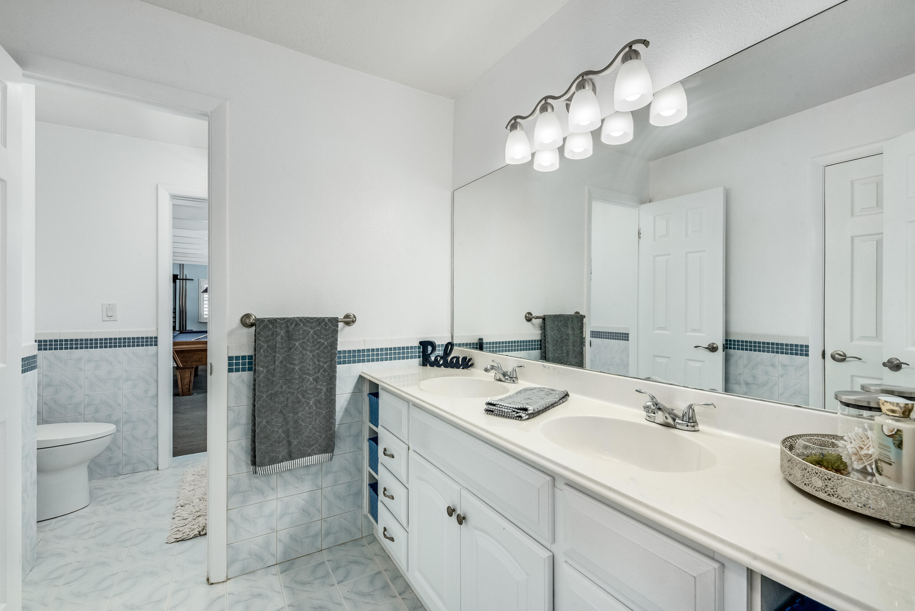 415 Wayne Avenue Indialantic, FL 32903 - Photo 29 of 63 a bathroom with a granite countertop sink a toilet and a mirror