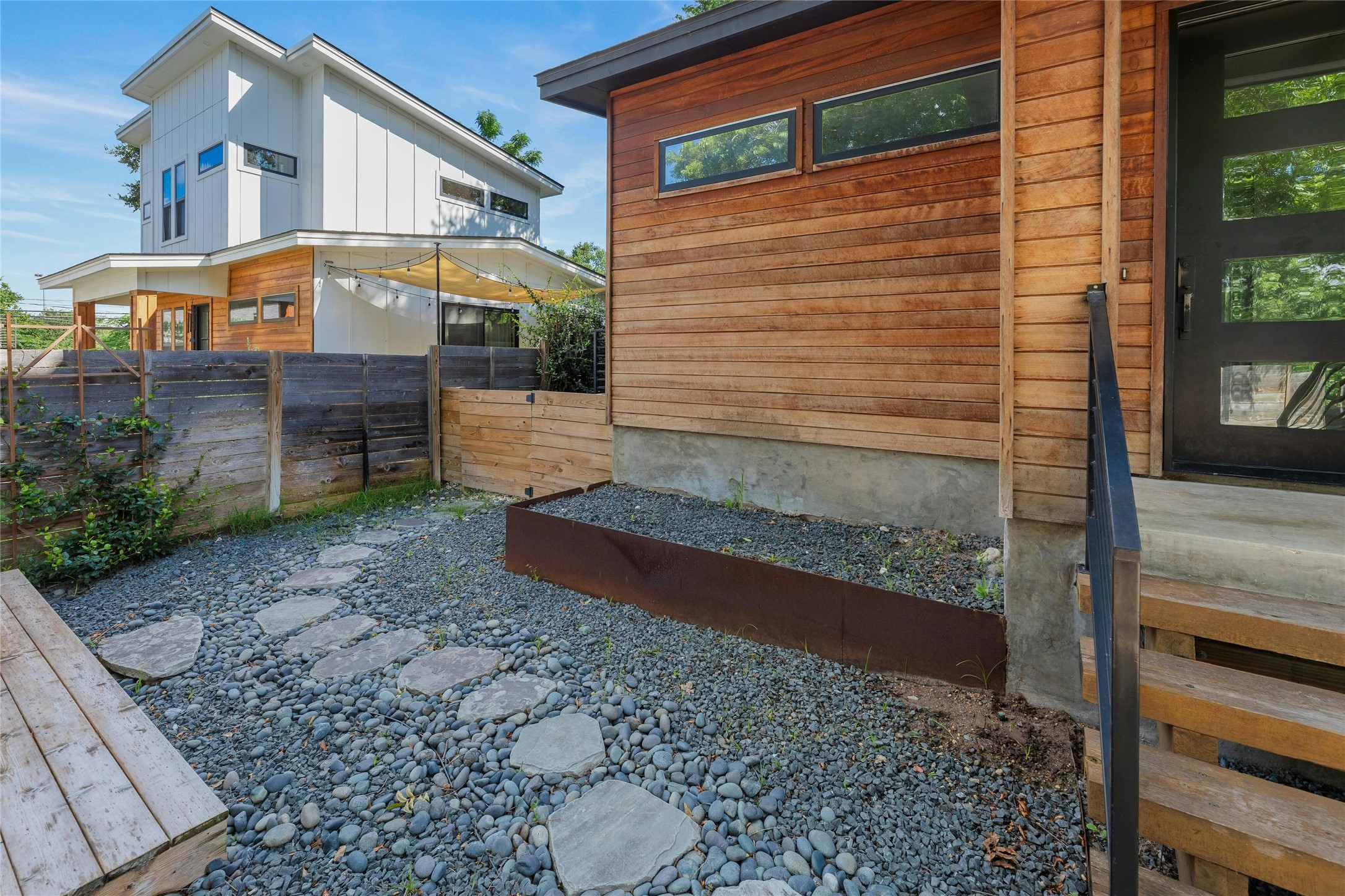 4606 Ledesma Road, Unit 2 Austin, TX 78721 - Photo 30 of 33 Modern wood siding and concrete foundations define this urban landscape, complemented by a gravel yard with stepping stones.