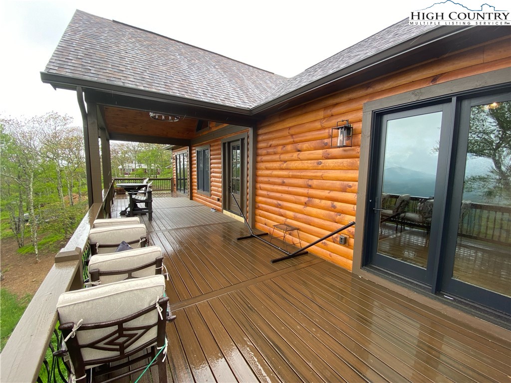 543 Broken Arrow Trail Boone, NC 28607 - Photo 32 of 35 a view of a patio with table and chairs with wooden floor and floor to ceiling window