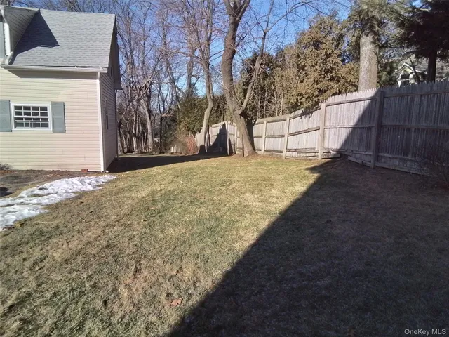 a view of a yard with wooden fence