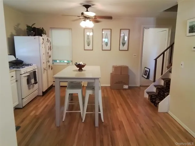 a view of a dining room with furniture a chandelier and wooden floor