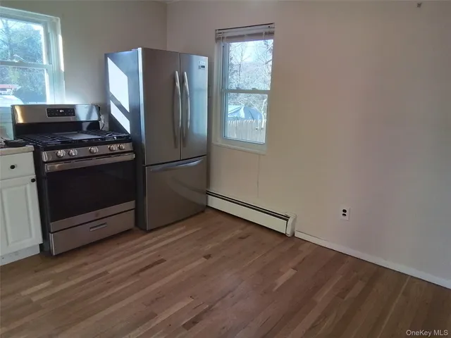 a kitchen with a refrigerator stove and wooden floor