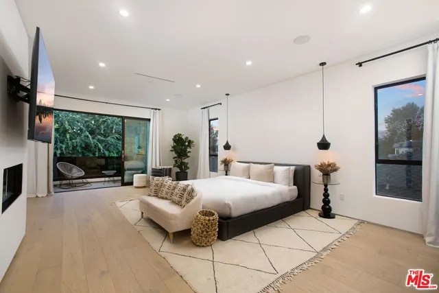 a bedroom with a bed and large window