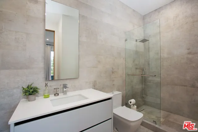 a bathroom with a sink toilet a mirror and shower