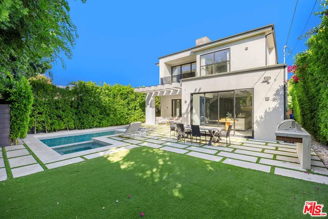 a view of a house with backyard sitting area and garden