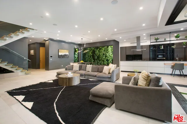 a living room with furniture and kitchen view