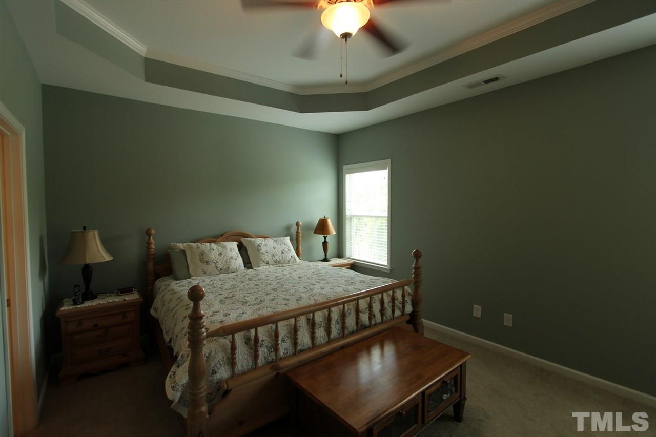 6312 Slopeside Court Raleigh, NC 27610 - Photo 11 of 22 a bedroom with a bed and a chandelier