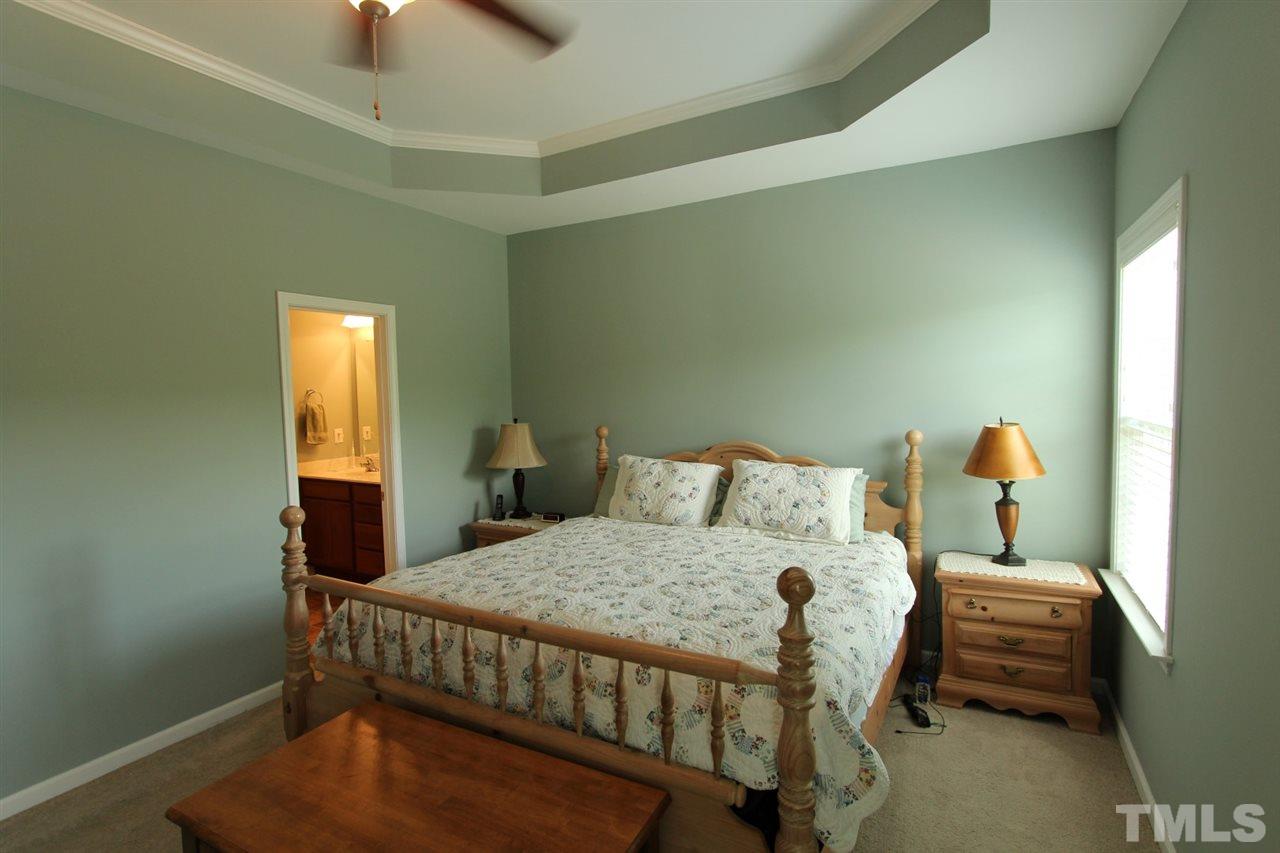 6312 Slopeside Court Raleigh, NC 27610 - Photo 12 of 22 a bedroom with a bed and wooden floor