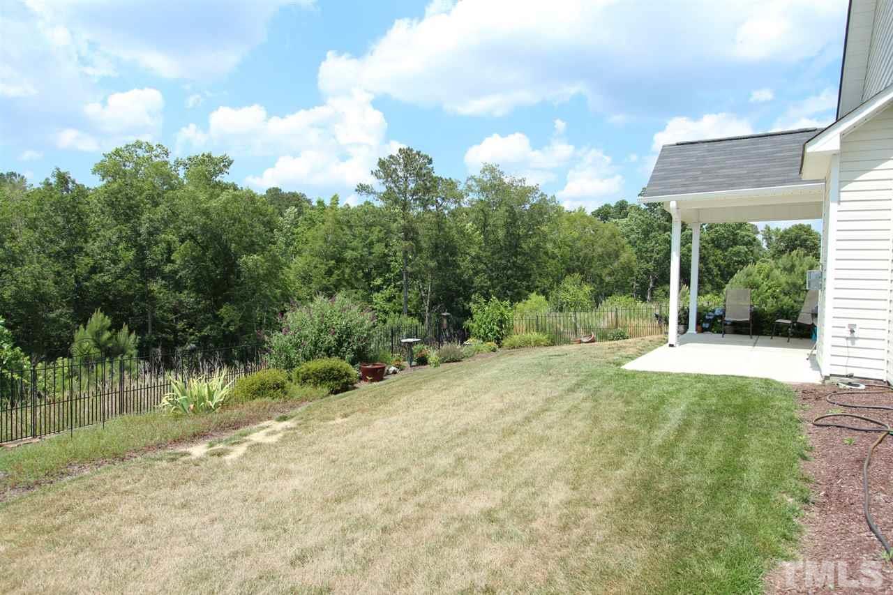 6312 Slopeside Court Raleigh, NC 27610 - Photo 21 of 22 a view of a yard with plants and a bench
