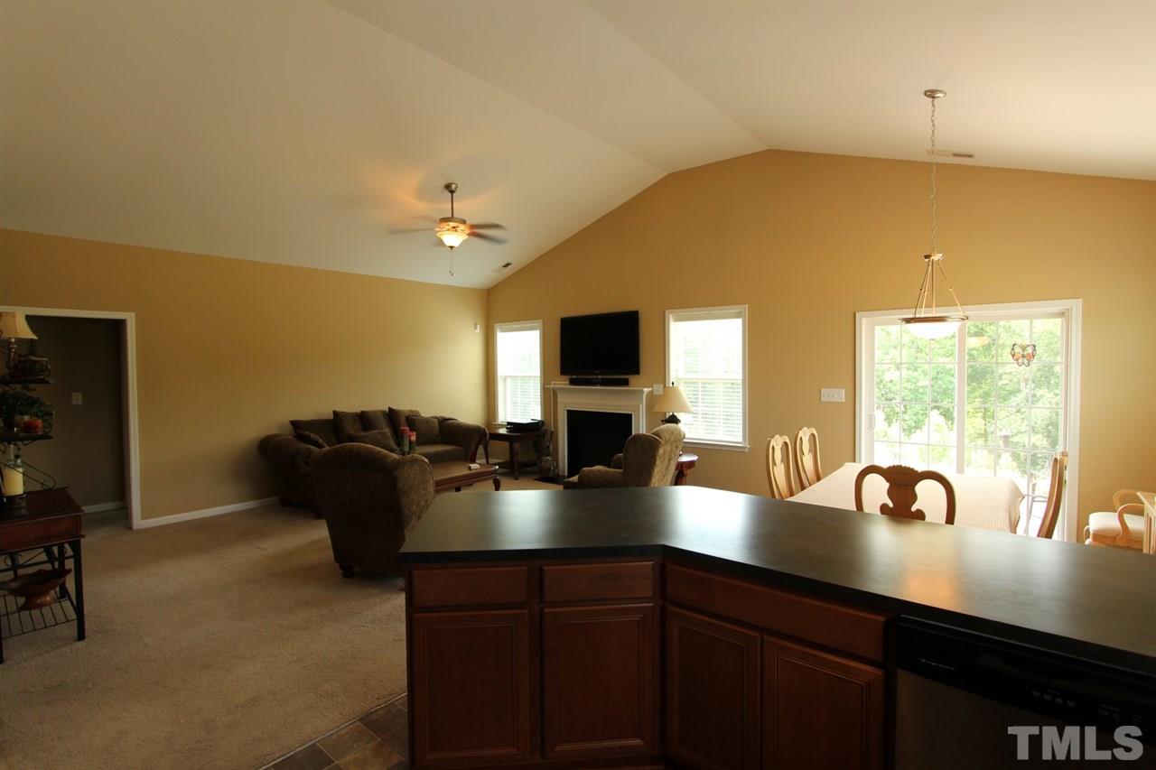 6312 Slopeside Court Raleigh, NC 27610 - Photo 5 of 22 a kitchen with a sink dishwasher a dining table and chairs with wooden floor
