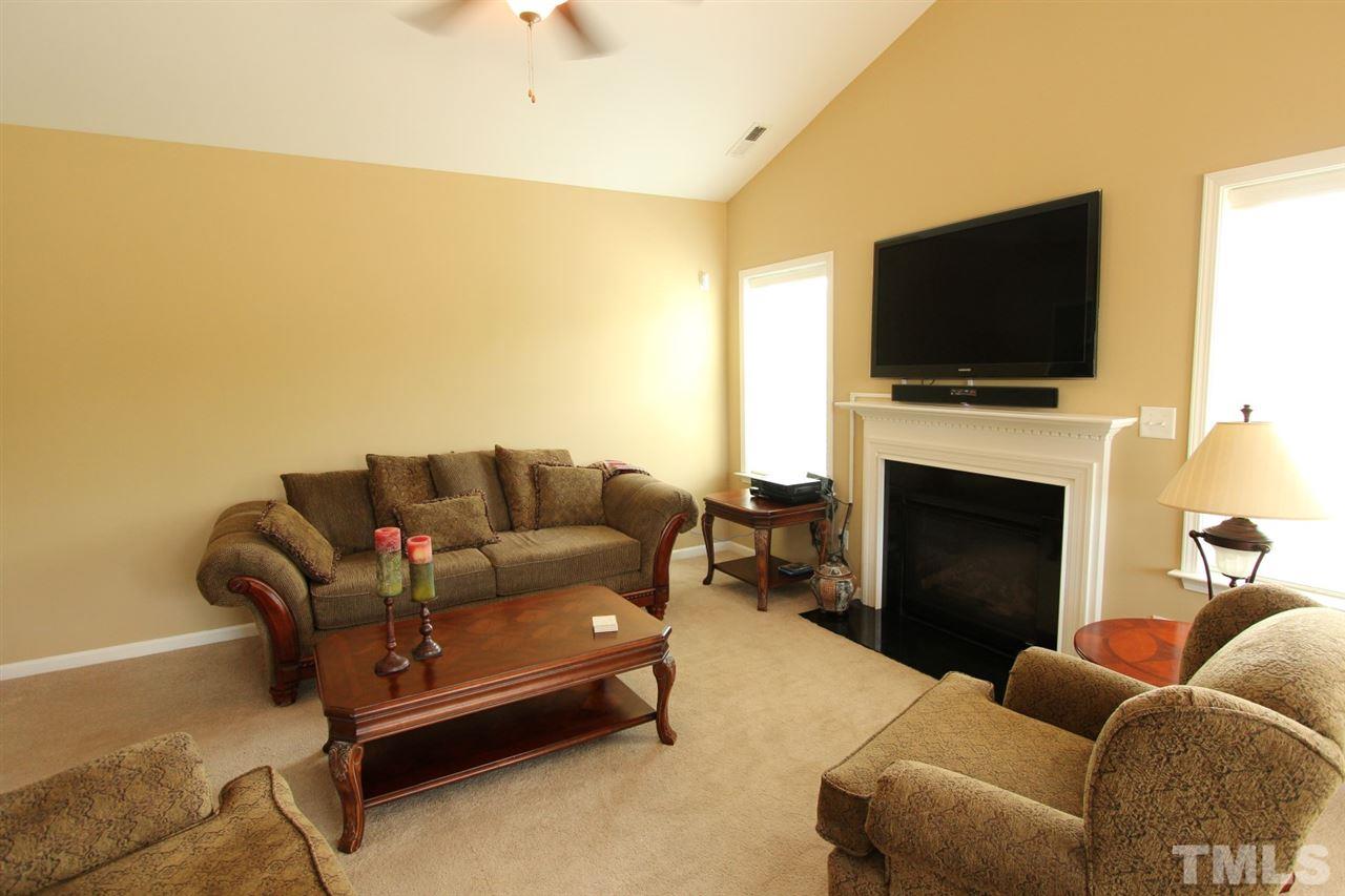 6312 Slopeside Court Raleigh, NC 27610 - Photo 7 of 22 a living room with furniture a flat screen tv and a fireplace