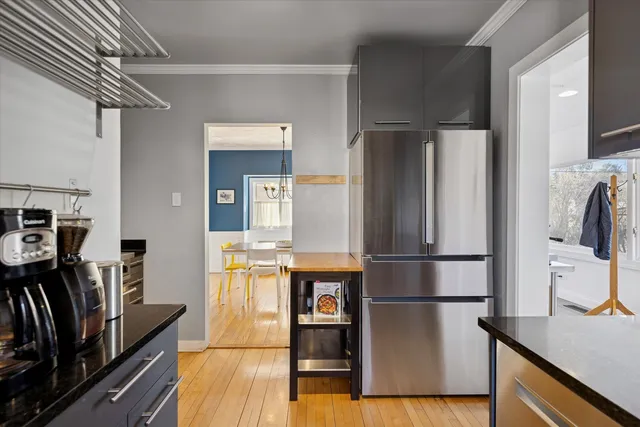 a kitchen with stainless steel appliances a refrigerator and wooden floor