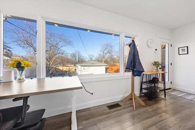 a living room with a table chairs and wooden floor