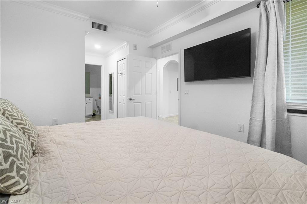 9596 Trevi Court, Unit 5413 Naples, FL 34113 - Photo 13 of 26 a bedroom with a bed and a flat screen tv