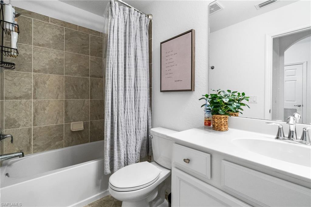 9596 Trevi Court, Unit 5413 Naples, FL 34113 - Photo 14 of 26 a bathroom with a sink a toilet a mirror a vanity and shower