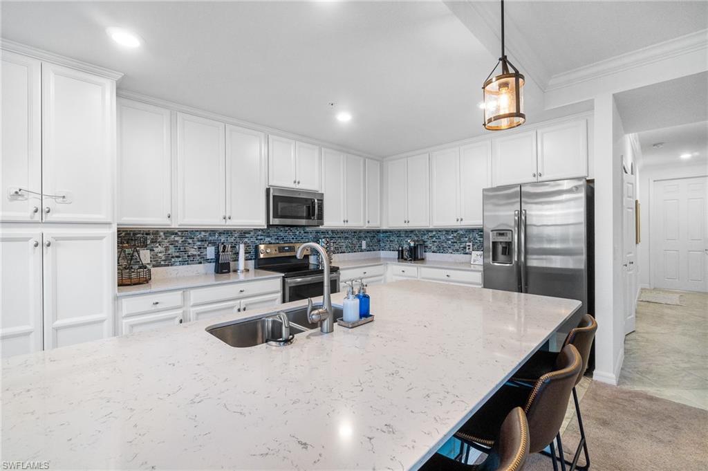9596 Trevi Court, Unit 5413 Naples, FL 34113 - Photo 6 of 26 a kitchen with refrigerator a stove and a sink with cabinets