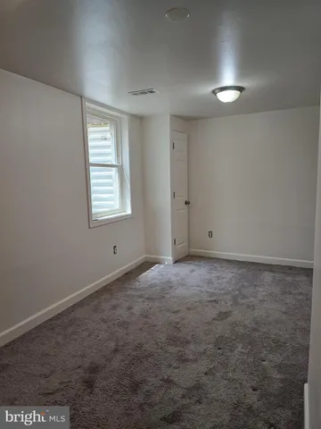 a spacious bedroom with a bed and a window