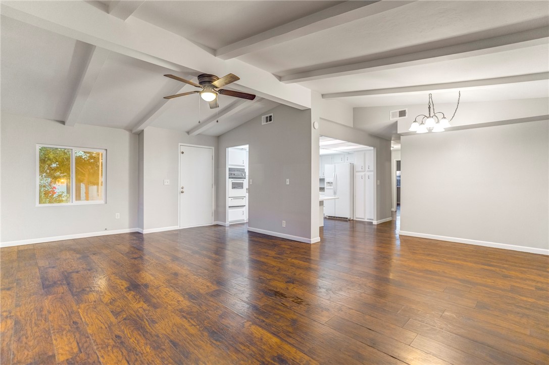 a view of a hallway with wooden floor and chandelier