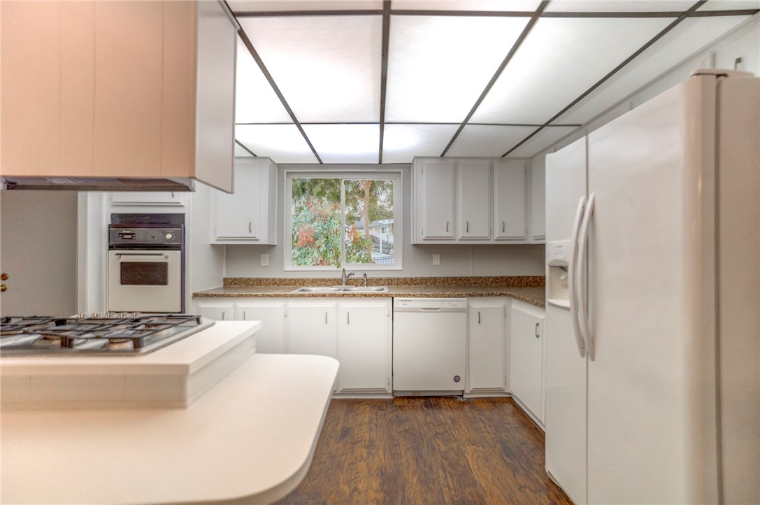 8536 Kern Canyon Road, Unit 184 Bakersfield, CA 93306 - Photo 11 of 28 a kitchen with kitchen island granite countertop a sink cabinets and stainless steel appliances