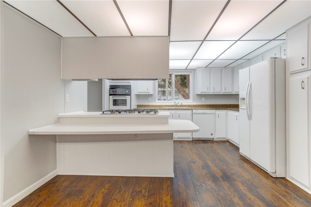 8536 Kern Canyon Road, Unit 184 Bakersfield, CA 93306 - Photo 9 of 28 a kitchen with stainless steel appliances a sink and wooden floor