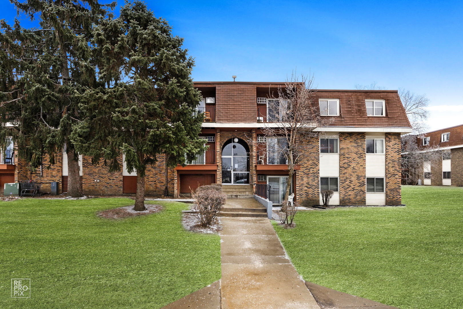 a front view of a building with a garden