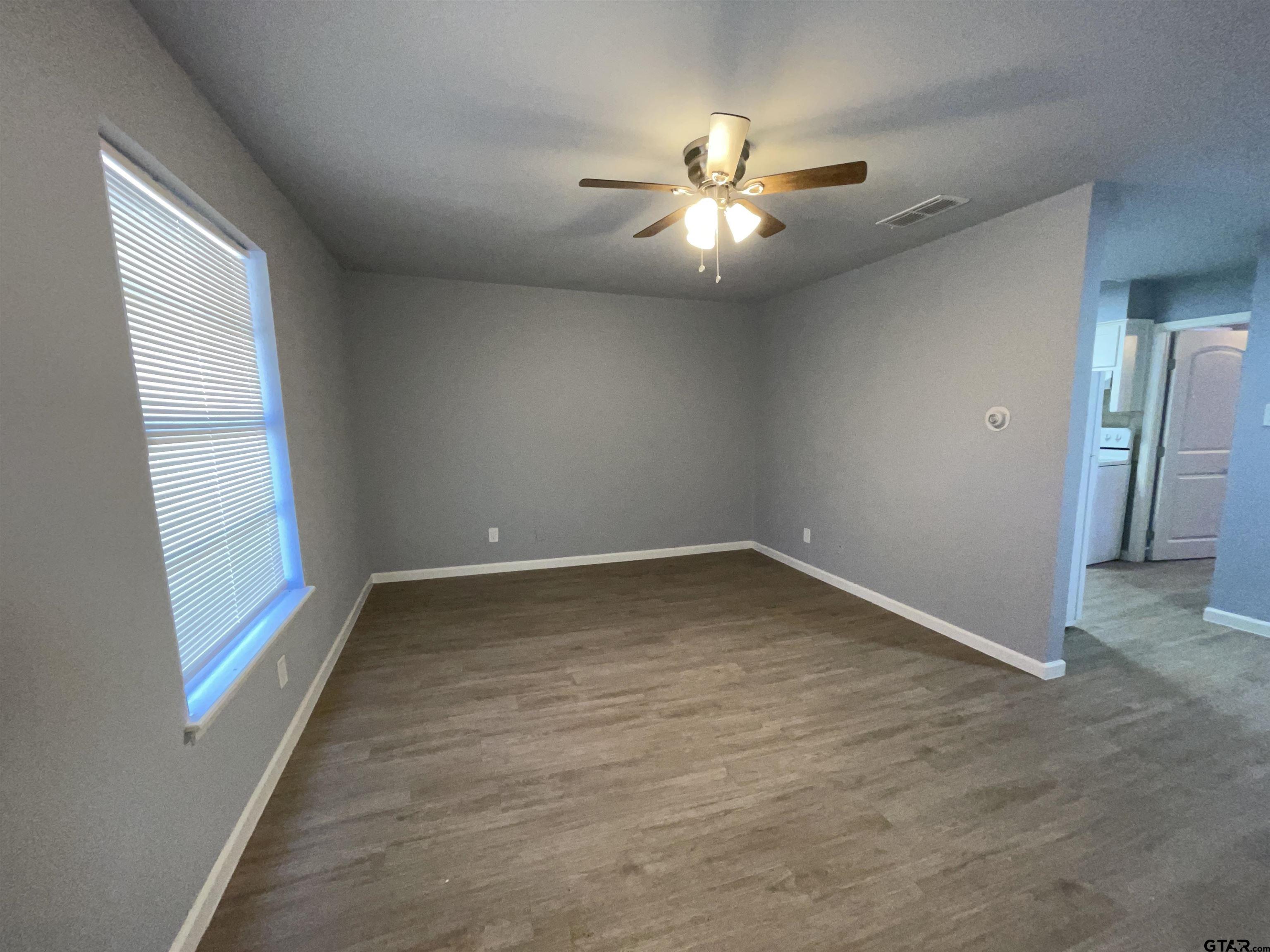 625 Augusta Avenue, Unit 10 Tyler, TX 75701 - Photo 3 of 9 an empty room with windows and fan
