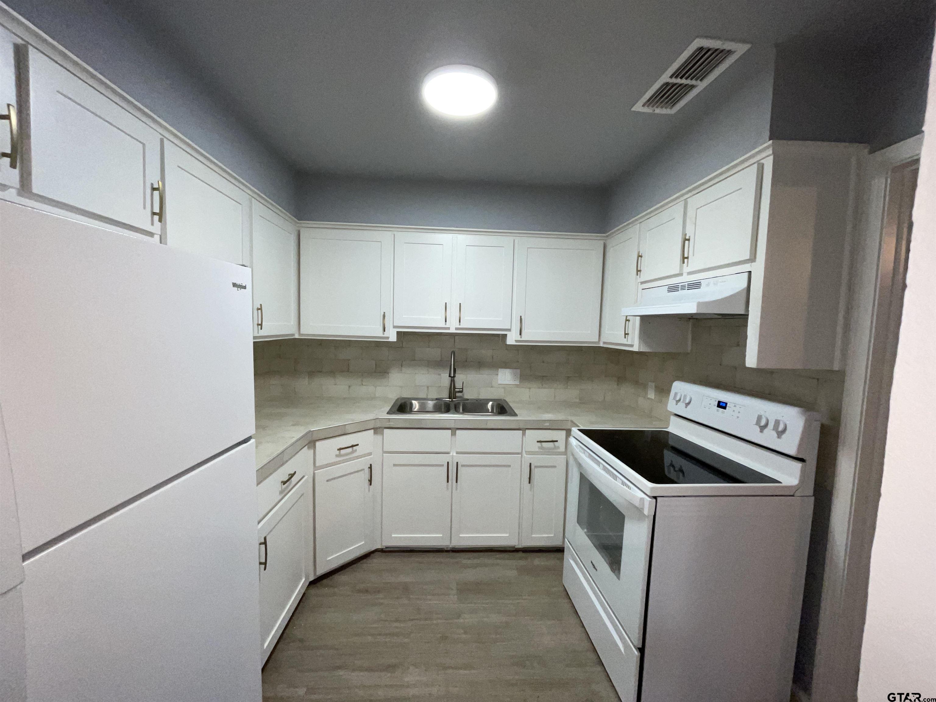 625 Augusta Avenue, Unit 10 Tyler, TX 75701 - Photo 5 of 9 a kitchen with stainless steel appliances granite countertop a sink stove and refrigerator