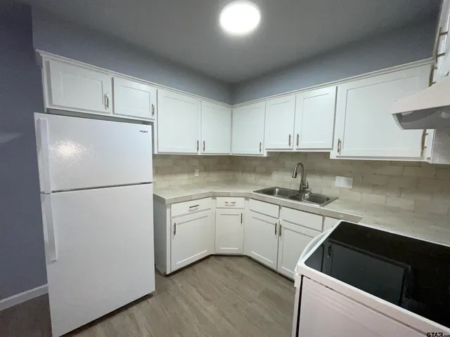 a kitchen with a refrigerator sink and cabinets
