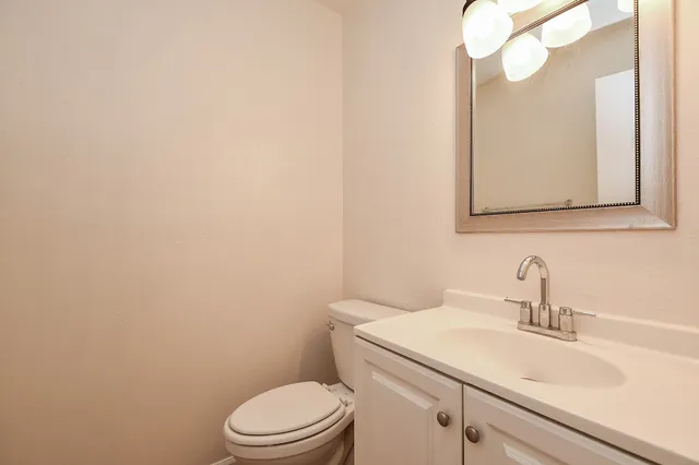a bathroom with a toilet a sink and mirror