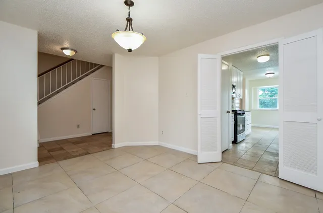 a view of a hallway with wooden floor and a chandelier