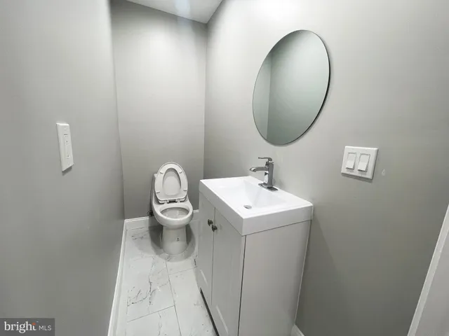 a bathroom with a toilet sink and mirror